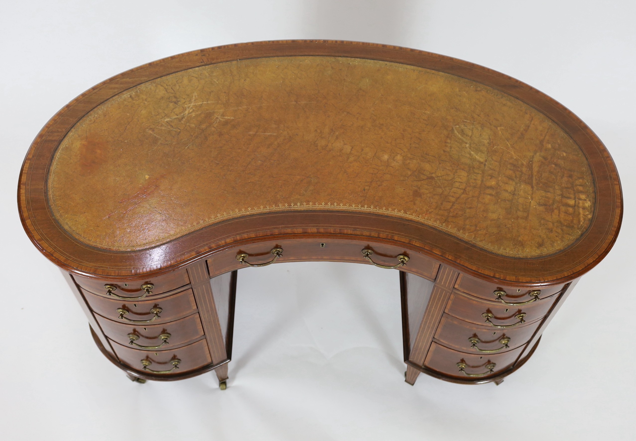 An Edwardian satinwood banded mahogany kidney shaped kneehole desk, W.122cm D.64cm H.77cm